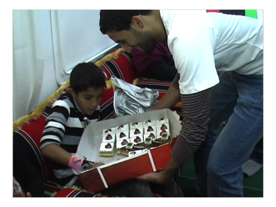 شاب يقدّم علبة حلوى لطفل في دار رعاية بالبيضاء
