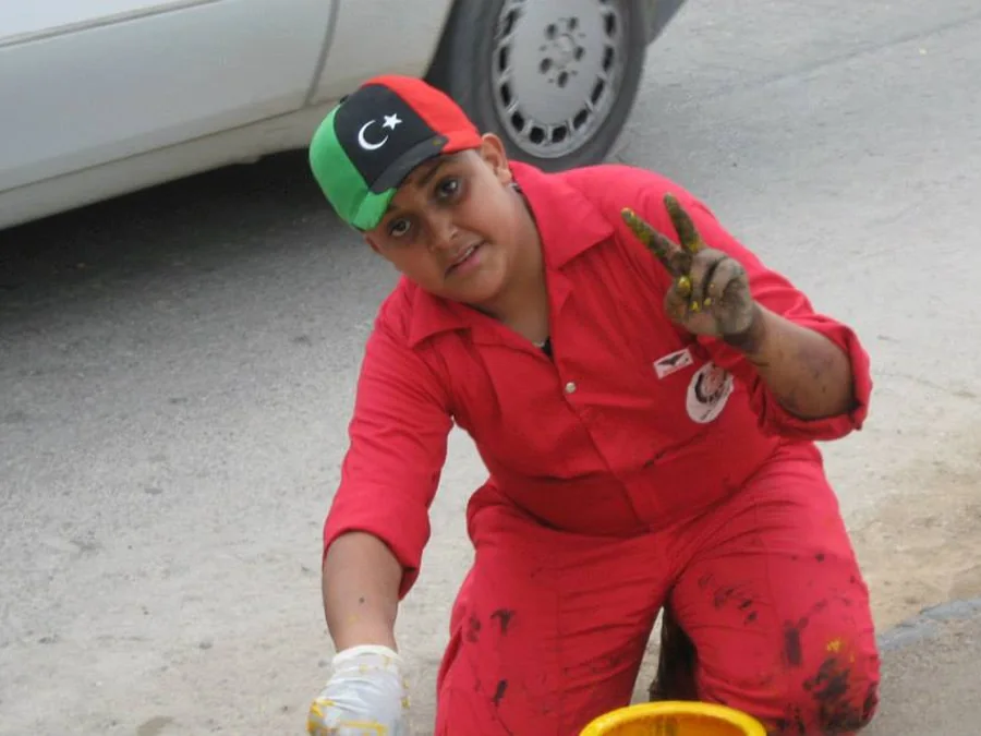 متطوعة بأيادٍ ملطخة بالطلاء ضمن حملة يدًا بيد لإعادة بناء ليبيا