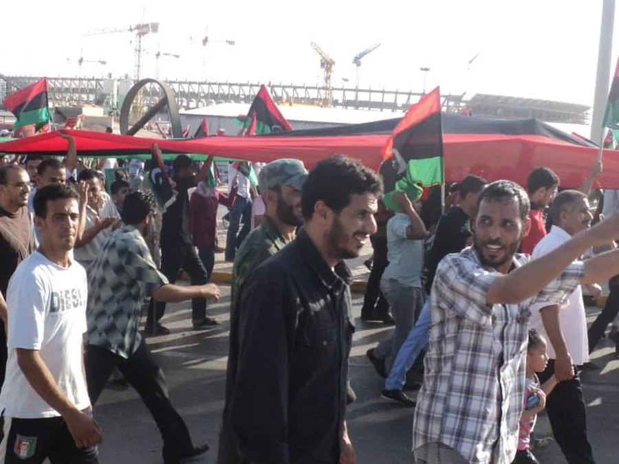 حشد كبير يسير حاملاً الأعلام الليبية في بنغازي